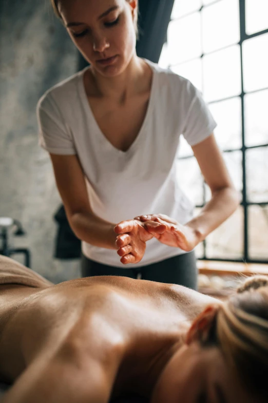 a woman getting a back massage from someone in the background