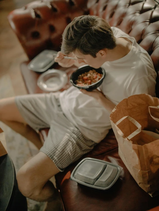 a man sitting down with a plate of food in his hands