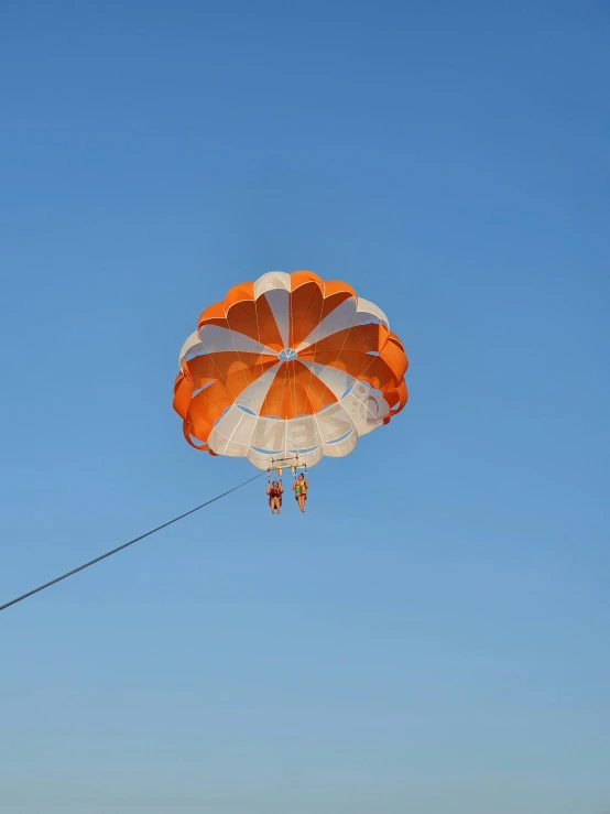 a large orange parachute being flown through the air