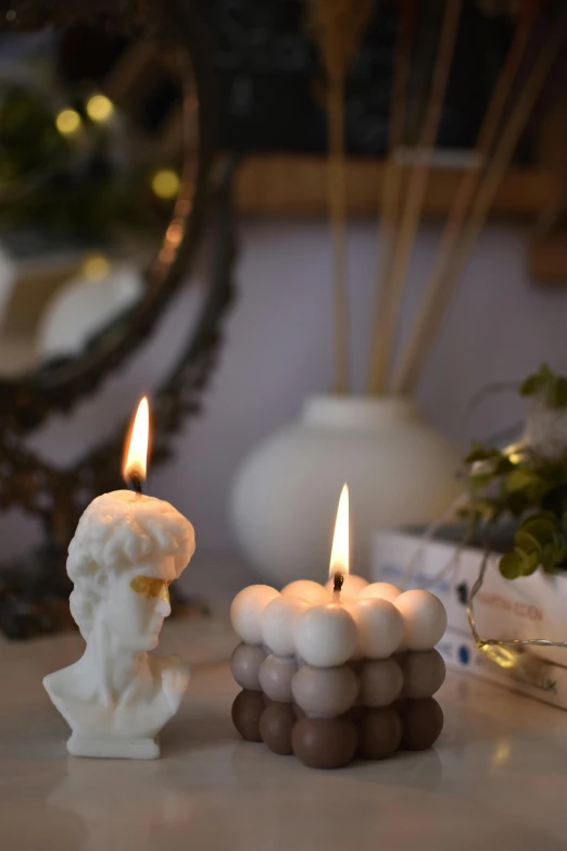 two candles sitting next to each other on top of a table