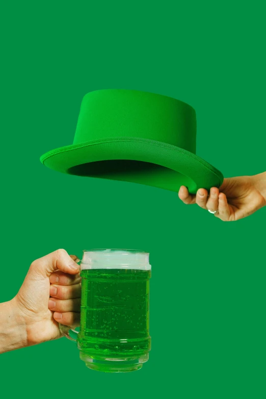 a person holding a glass with green liquid in it