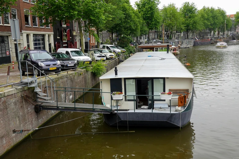 a small house boat tied to the side of the river