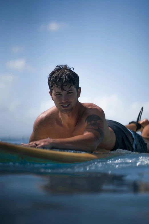 the young man is laying on his surfboard in the water