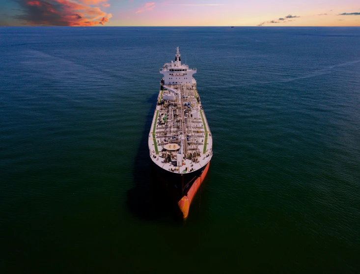 a cargo ship is anchored at the edge of the ocean