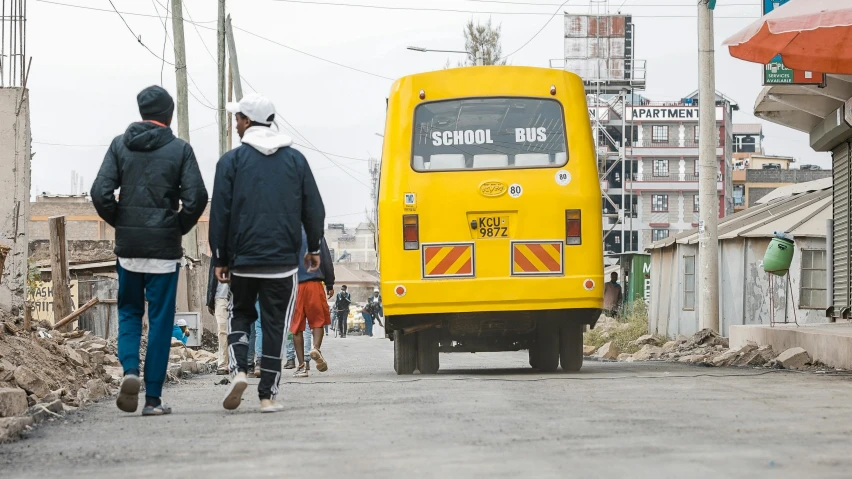 a man and woman are walking toward a school bus