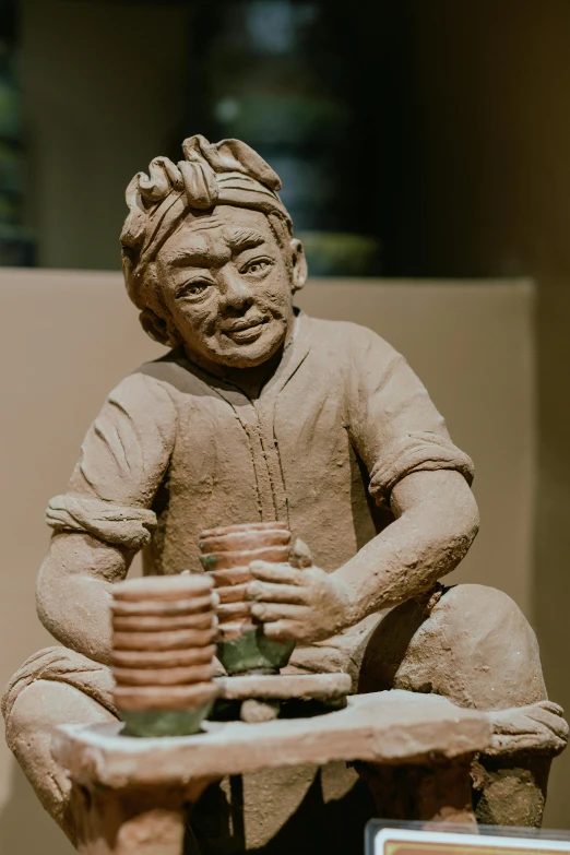 a decorative clay sculpture of an old asian man with stacked dishes