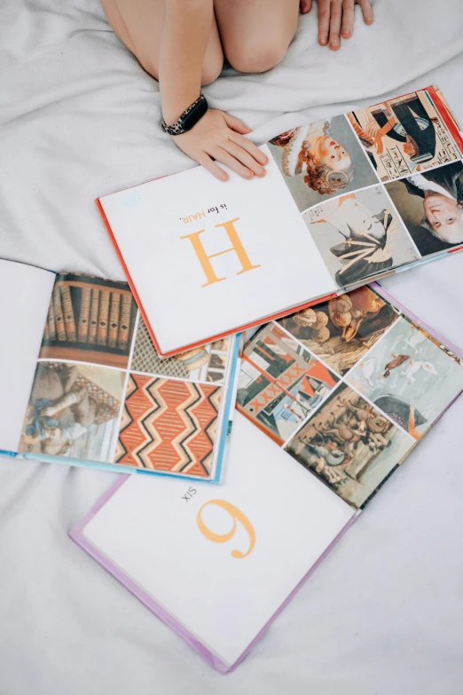 a woman laying on top of a bed covered in pictures