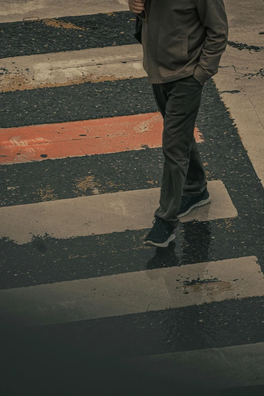 a man is crossing the street while holding an umbrella