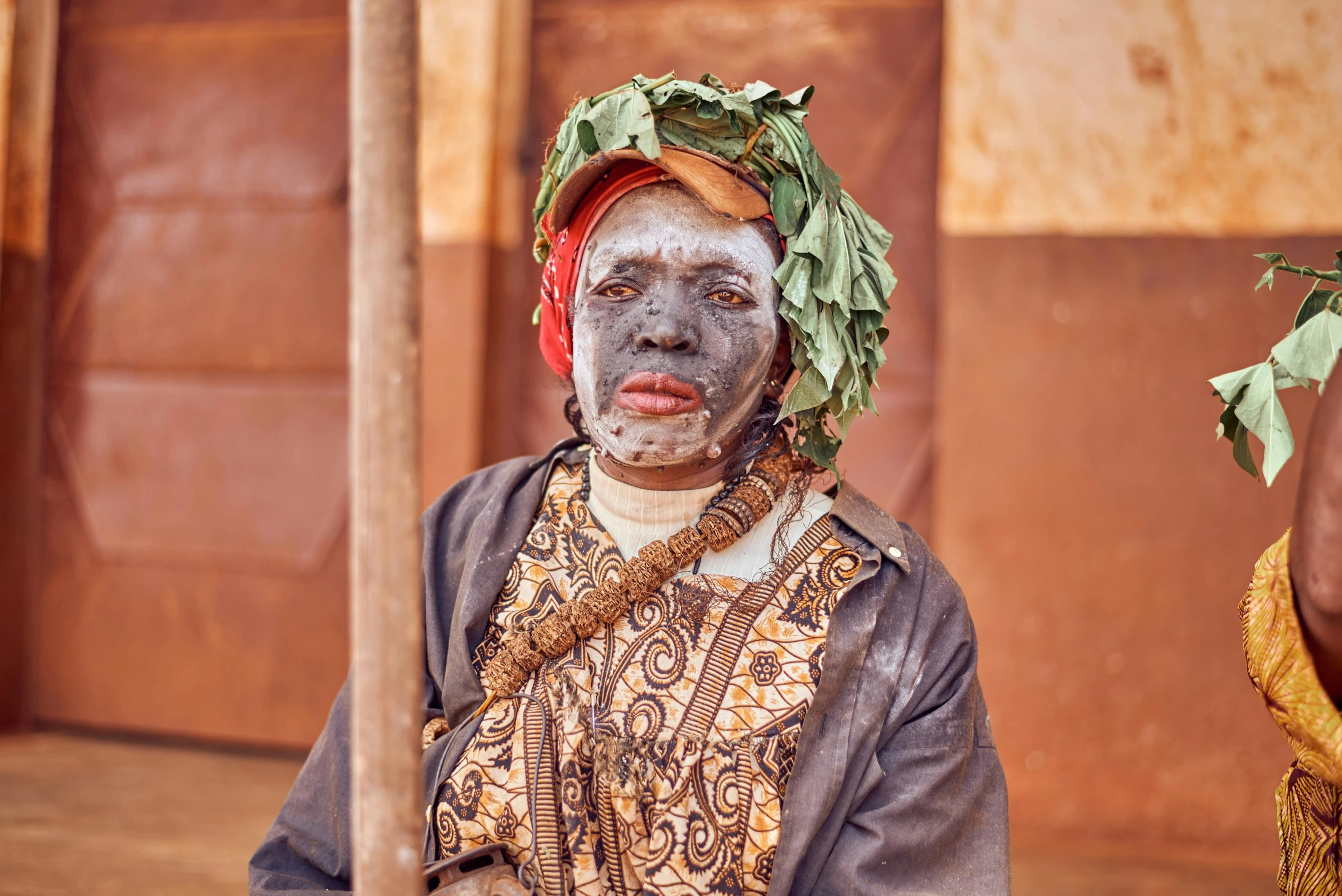 a man with painted face and make up on with a flower