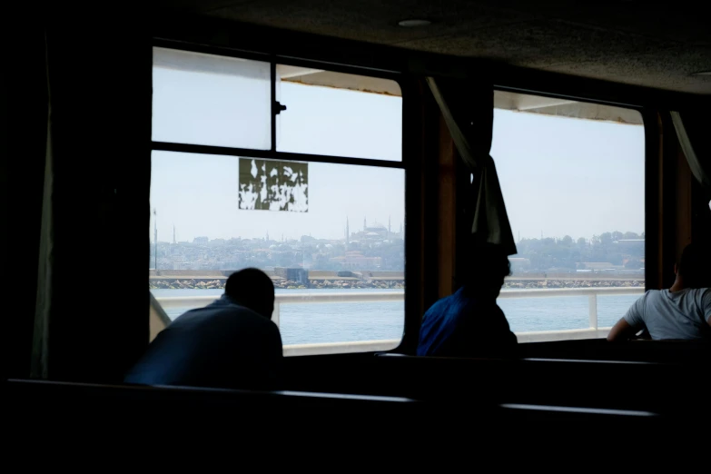 two people sitting down in the bus looking out of windows