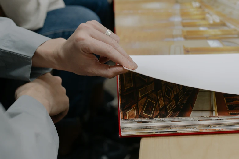 a person removing a paper from the edge of a piece of art work