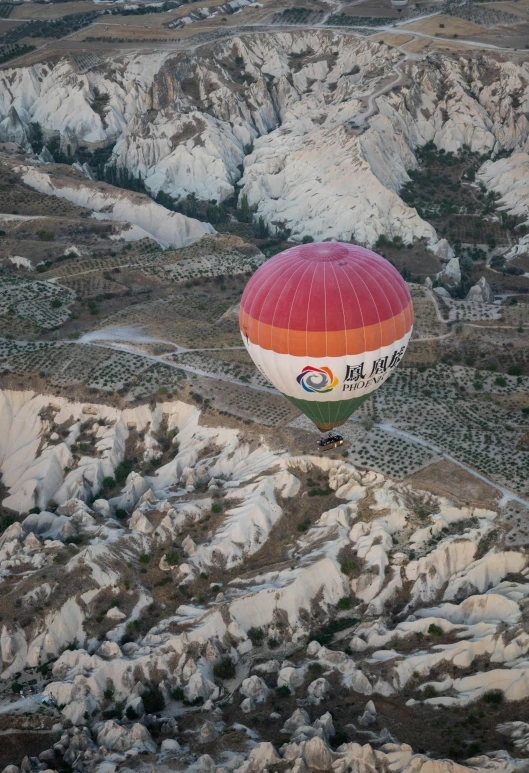 an air ballon flying in the sky above some mountains