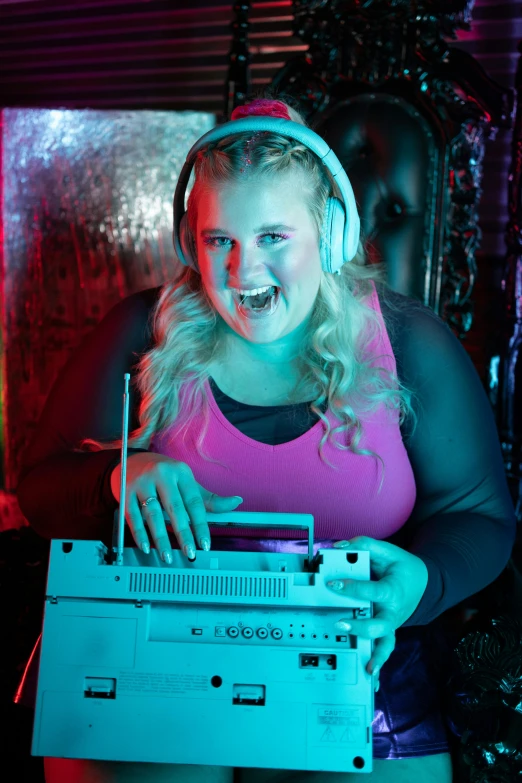 a woman wearing headphones is smiling while holding an old tape drive