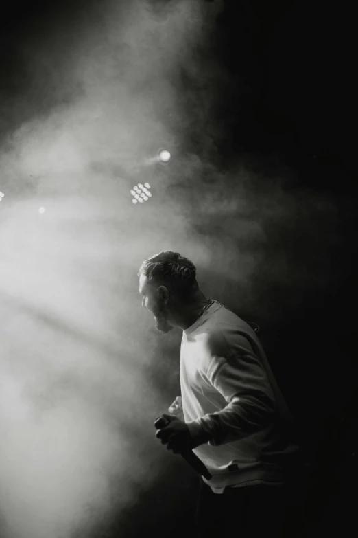 man standing under a spotlight in a dark spot