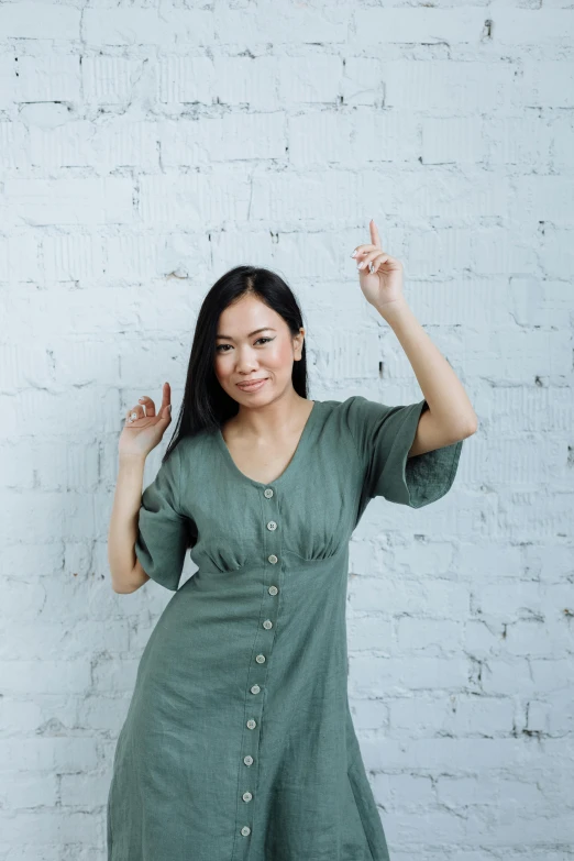 a woman wearing a green dress and posing for the camera