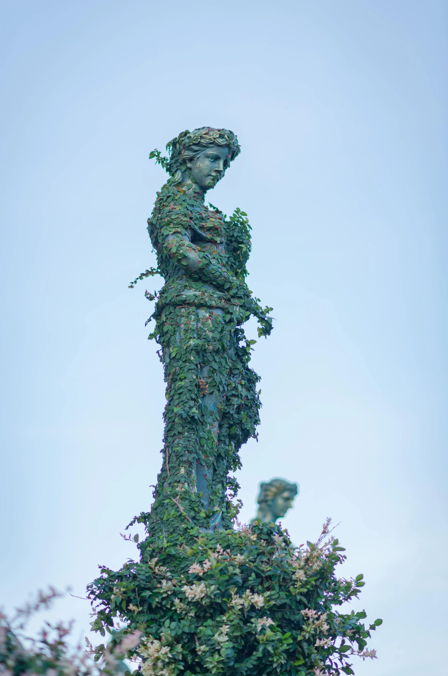 the sculpture is covered with vines and flowers