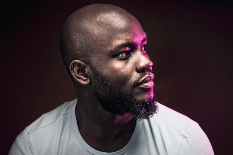 a man in a white shirt with a pink light on his face