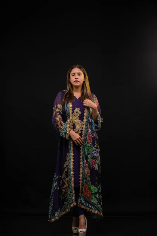 a woman standing in front of a black backdrop