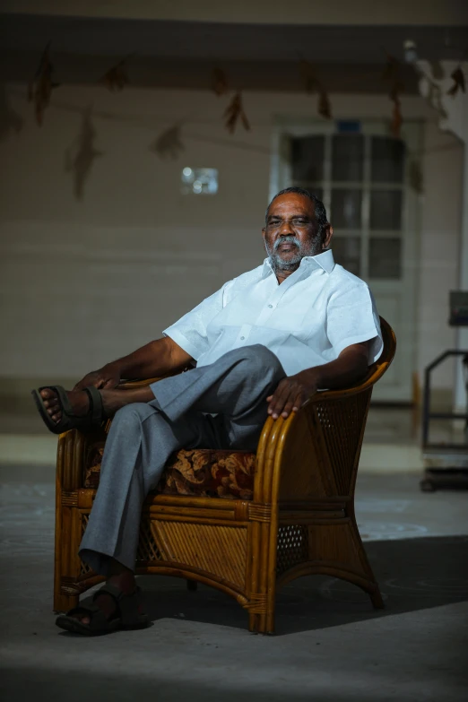 a man with grey hair is sitting in a chair