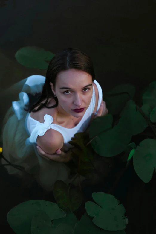 a woman wearing a white top is floating in water