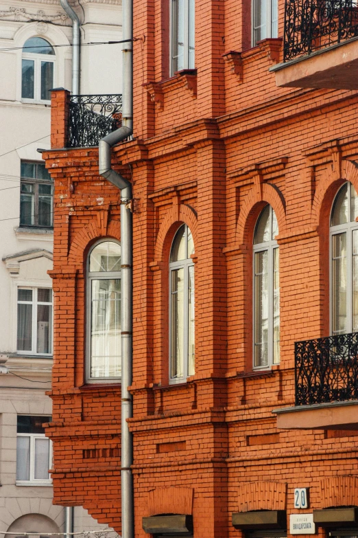 orange brick building with iron balcony railing and balconies