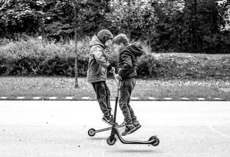 two s play on the street on their scooters