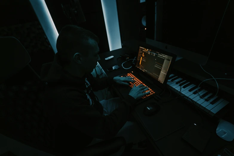 a person using a keyboard at a table with electronic items