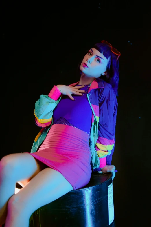the woman is sitting on top of the table in the neon color dress