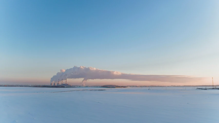 a large puffy cloud hangs over a snowy landscape