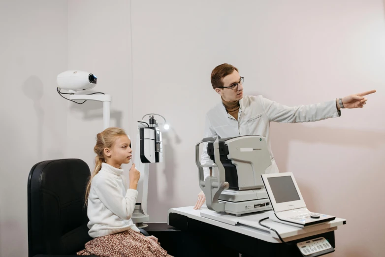 a man and a little girl watching soing at the dentist