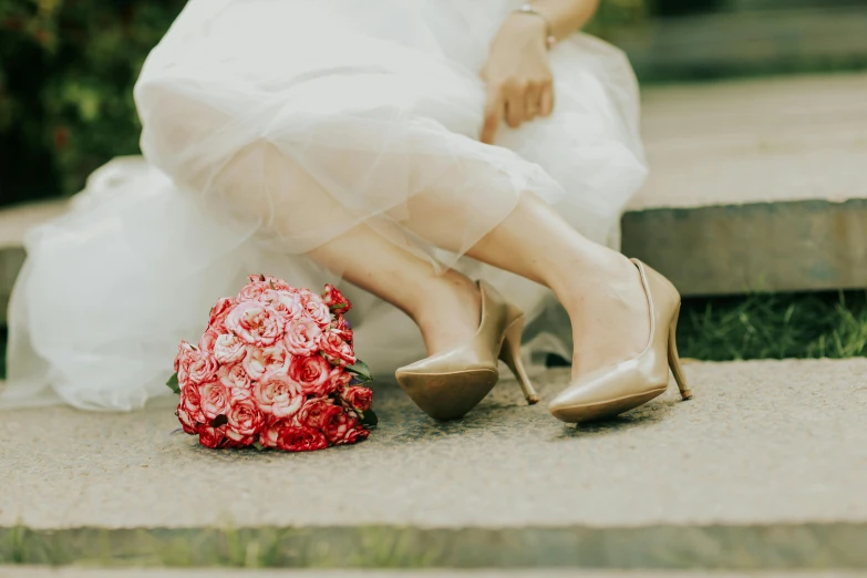 a bride and her shoes on the steps next to a bouquet