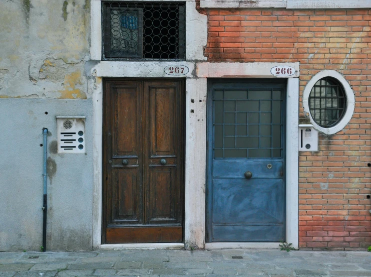 two doors that are sitting next to a brick building