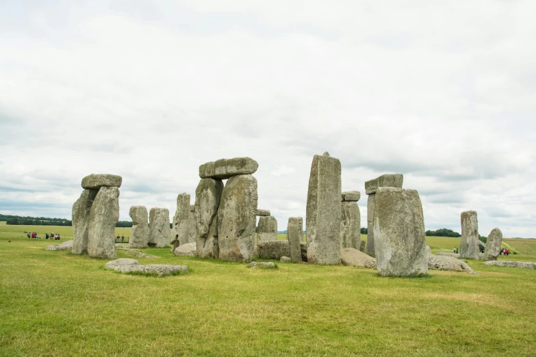 the stone formations are sitting in a grassy field