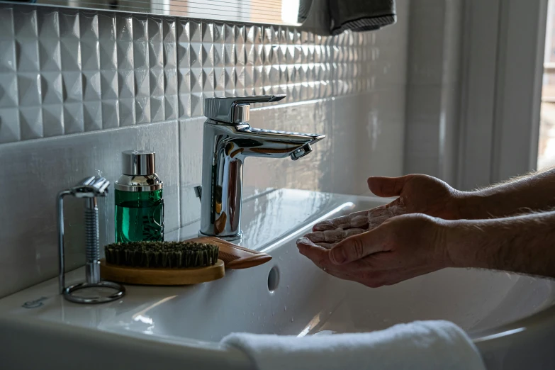 person washing their hands with a brush and soap