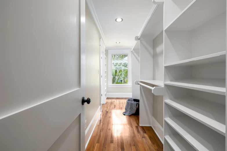 an empty walk in closet with shelving on the wall