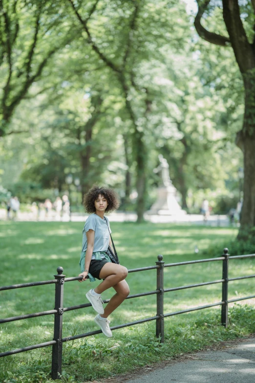 a woman posing with her leg against a fence