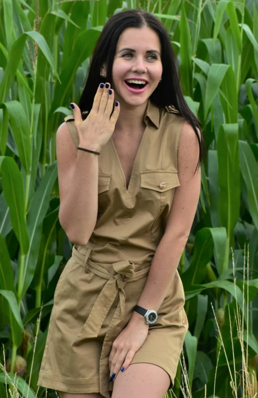 a woman posing for the camera in front of grass