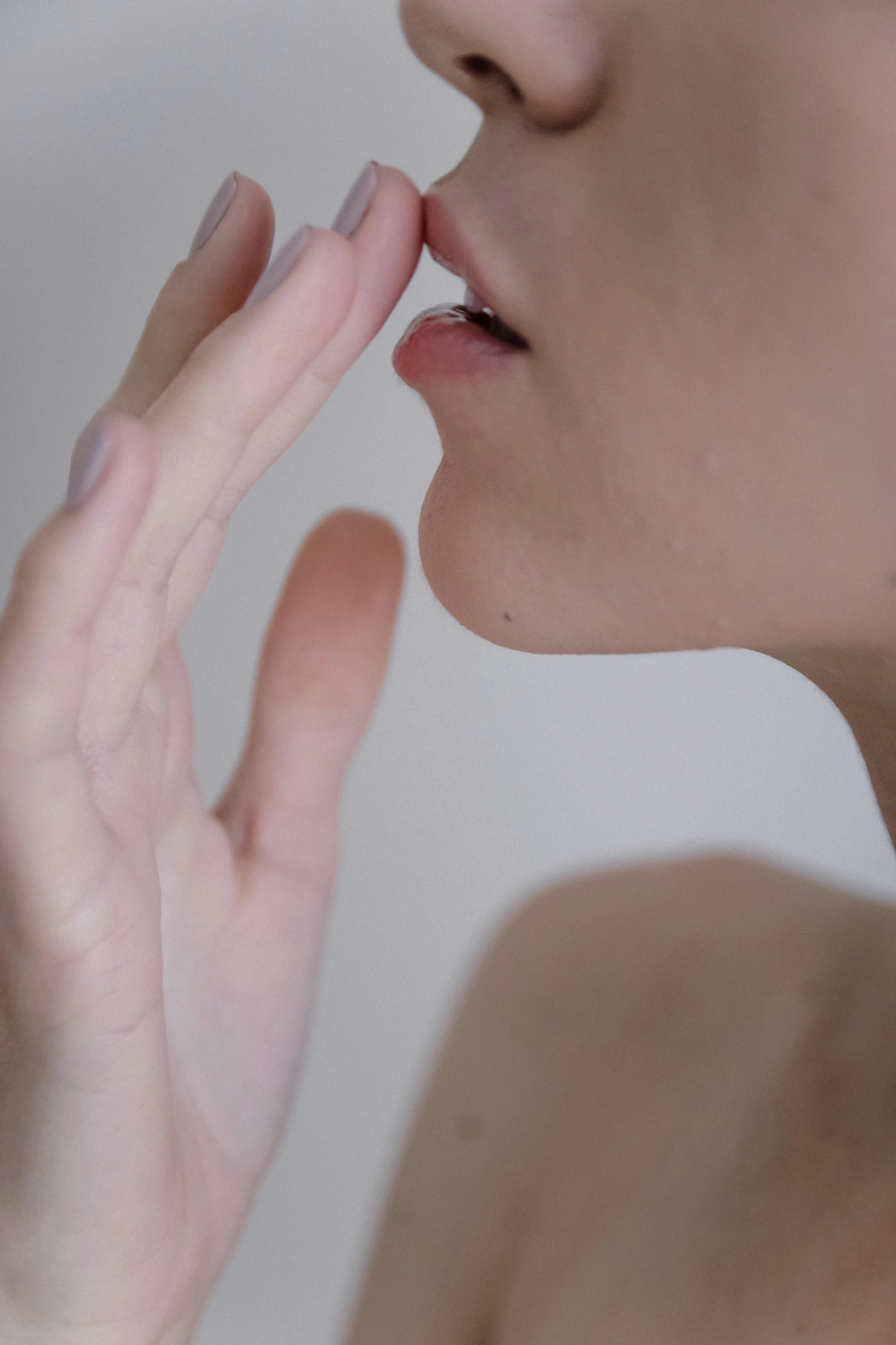 a woman with her hand on her nose touching her lips