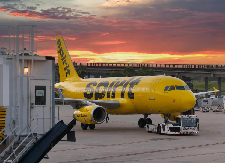 a yellow and black plane parked in front of an airport terminal