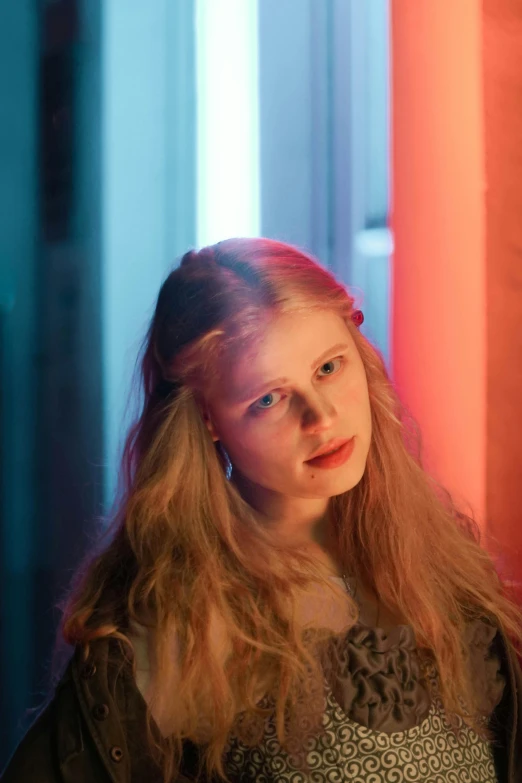 young lady in dark dress with red light coming from column