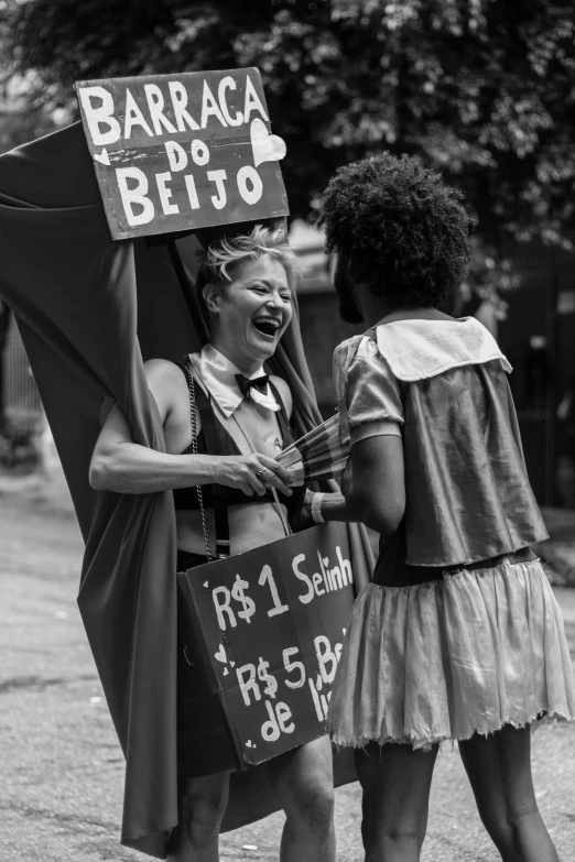two ladies are standing next to each other with signs on their heads