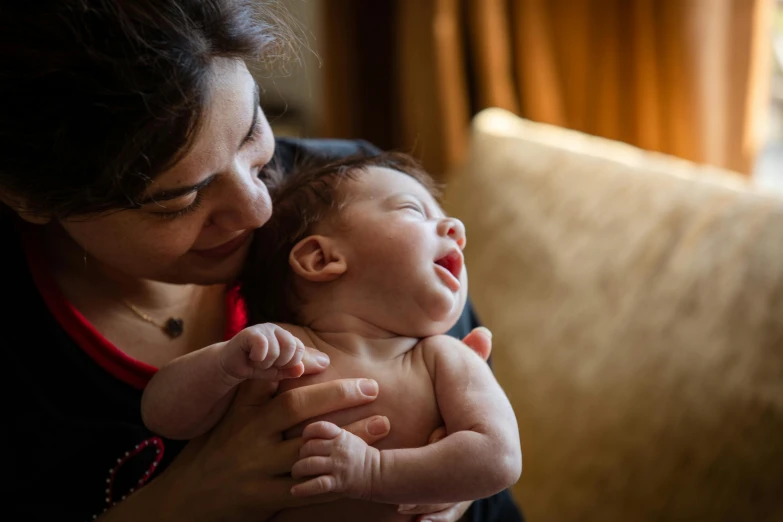 a woman holding a baby in her arms and laughing