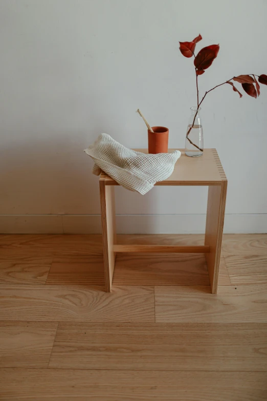 a wooden table with two cups and a blanket on it