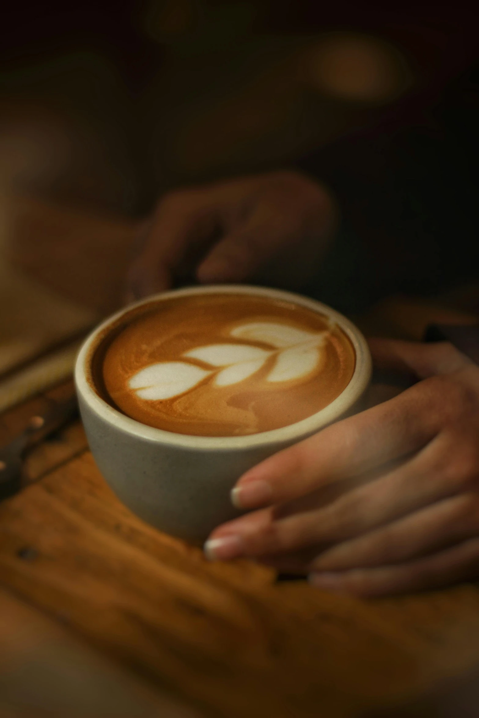 a person holding a cup of latte art coffee