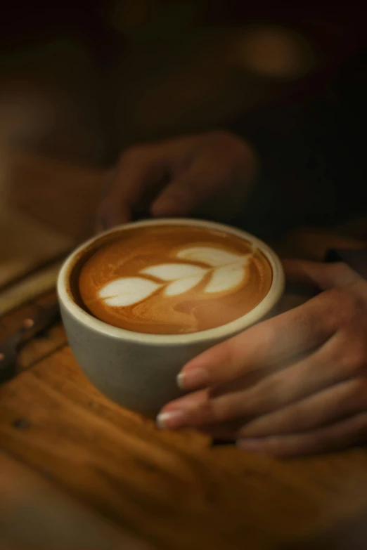 a person holding a cup of latte art coffee