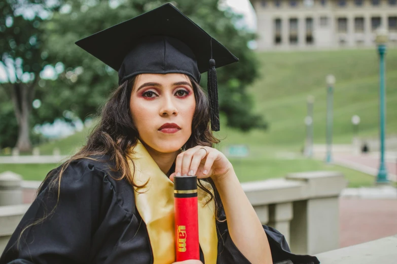 the graduate woman is posing with her cap and gown