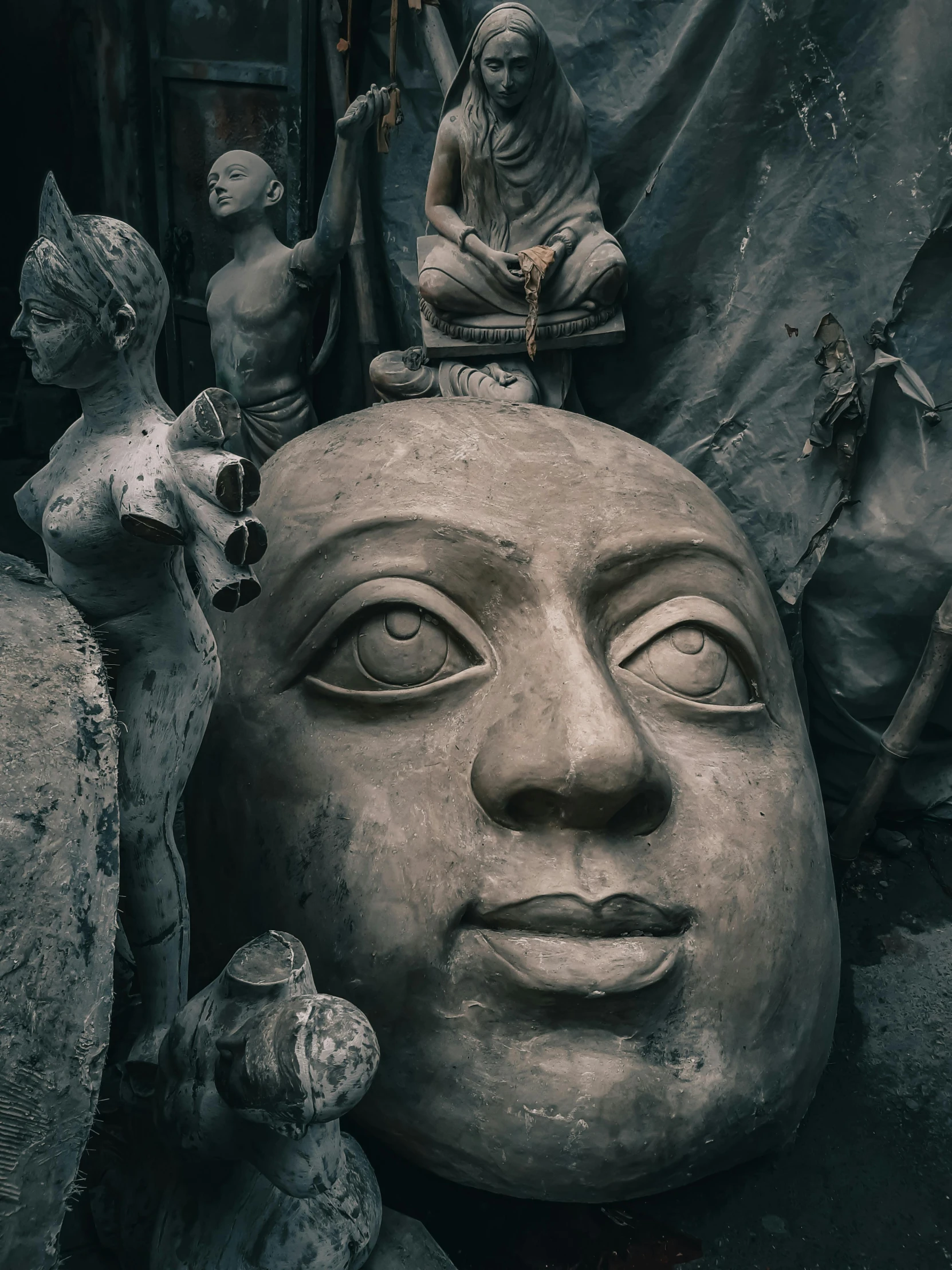 a sculpture of the face of a man is surrounded by rocks