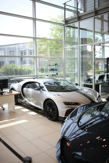 two sports cars in a showroom next to each other