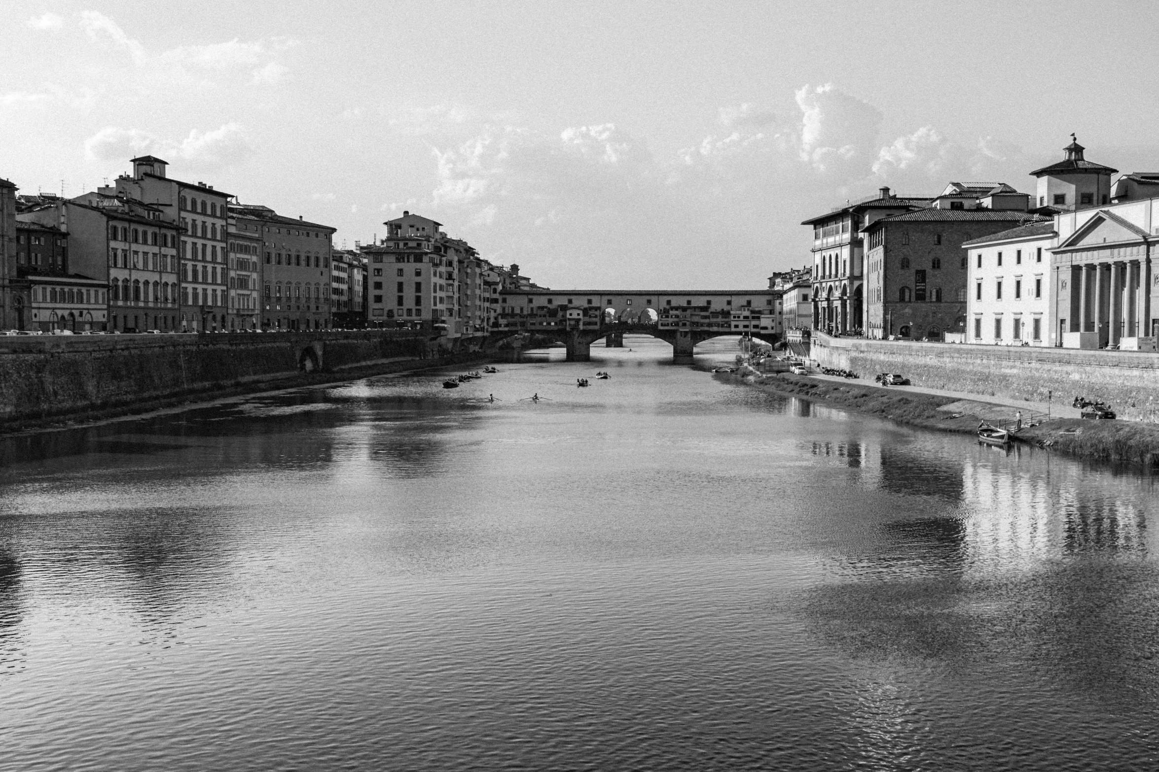 a small river runs alongside old buildings on the other side