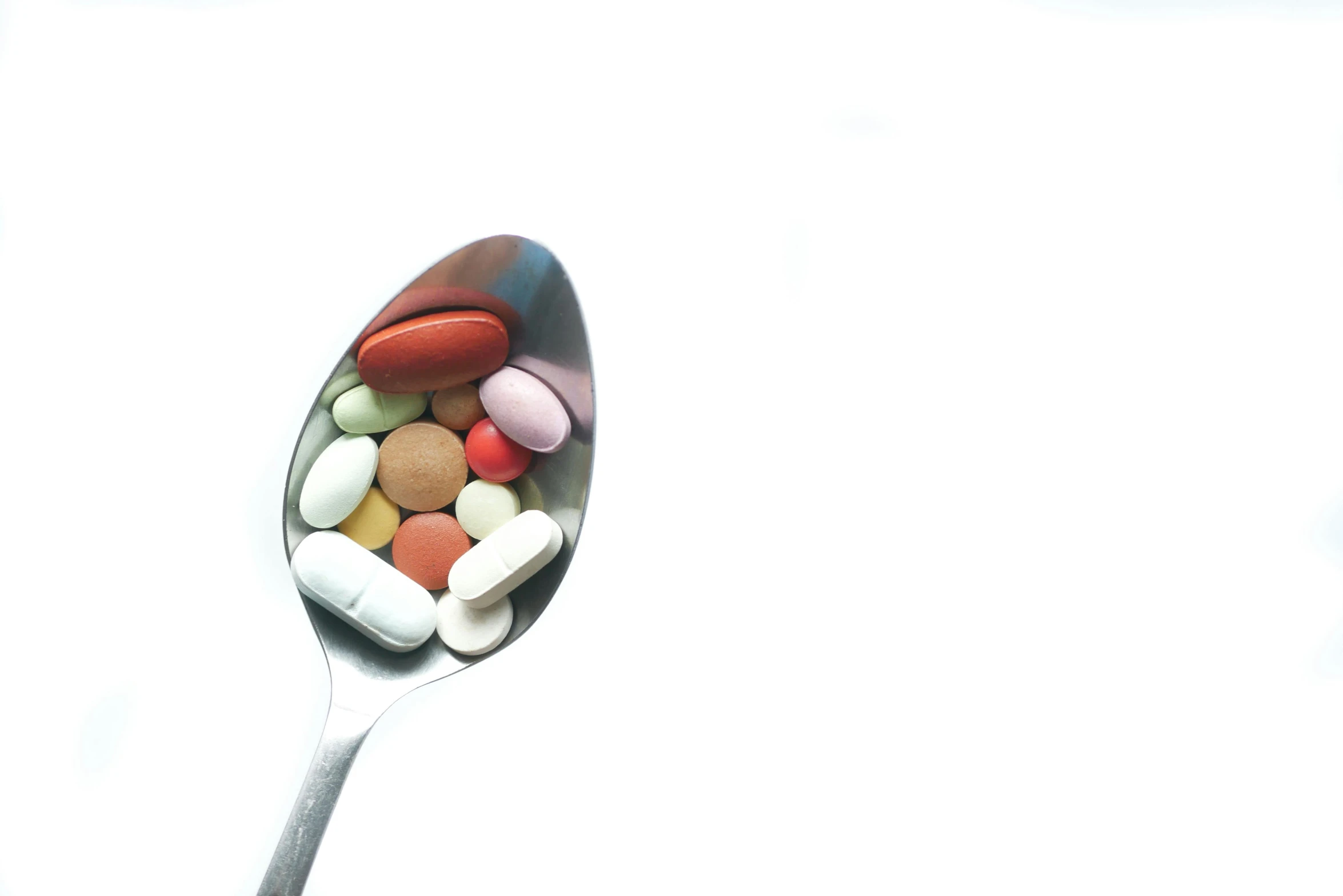 a spoon with pills sitting on top of it